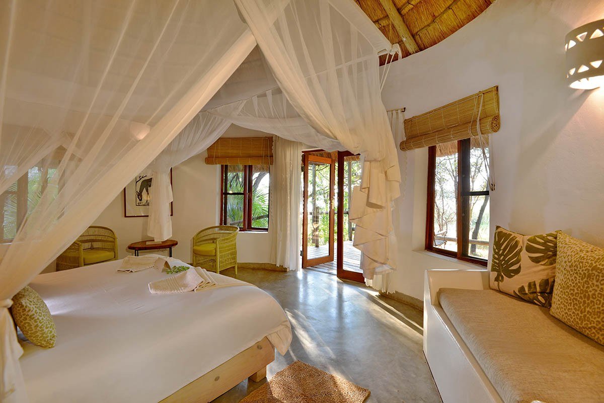 Tented bedroom with a mosquito net canopy at Chobe Bakwena Lodge