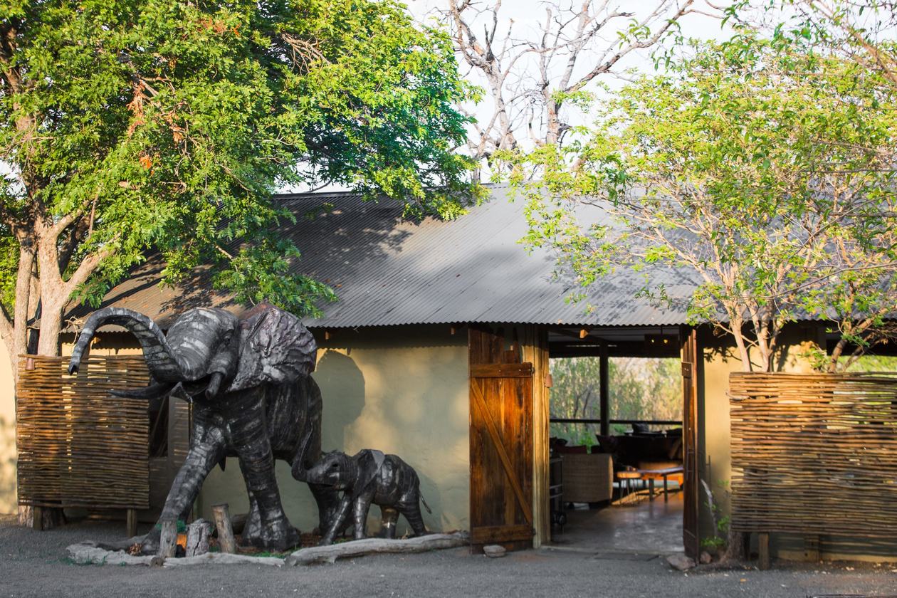 Thatched entrance with carved elephant statues at Chobe Elephant Camp, Chobe