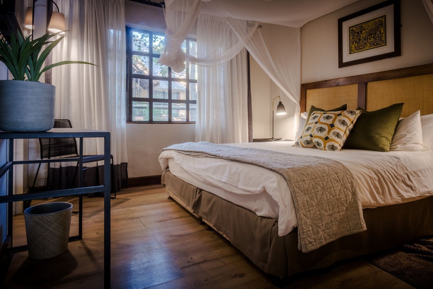 Bedroom with a four-poster canopy bed at Chobe Marina Lodge