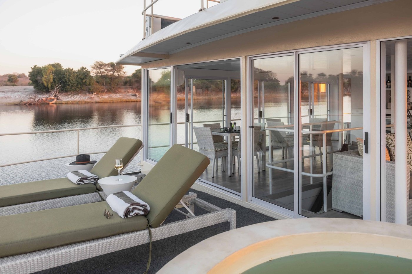 Covered deck lounge with seating overlooking the water at Chobe Princess
