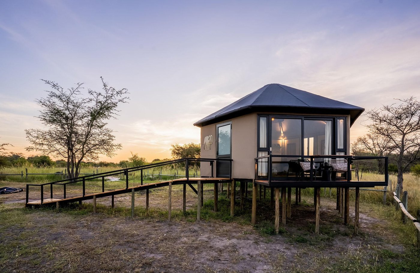 Elevated tented chalet on a raised walkway at dusk at Chobe River Camp