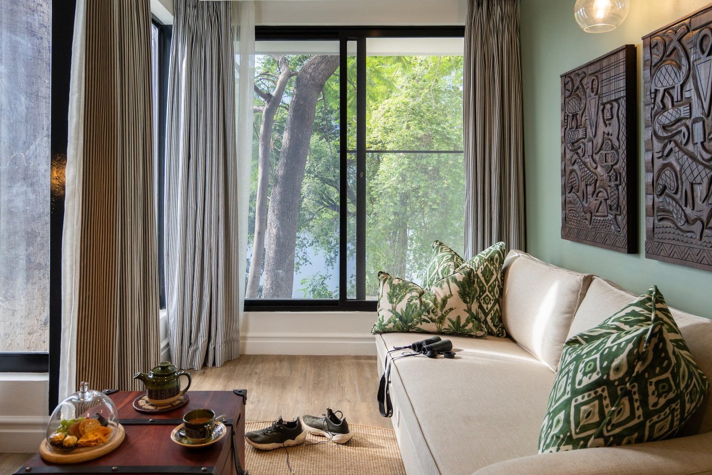 Lounge seating area with a white sofa and wall art at Chobe Safari Lodge