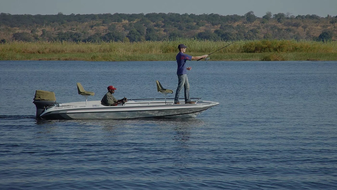 Guest fly-fishing from a boat on the river near Chobe Safari Lodge