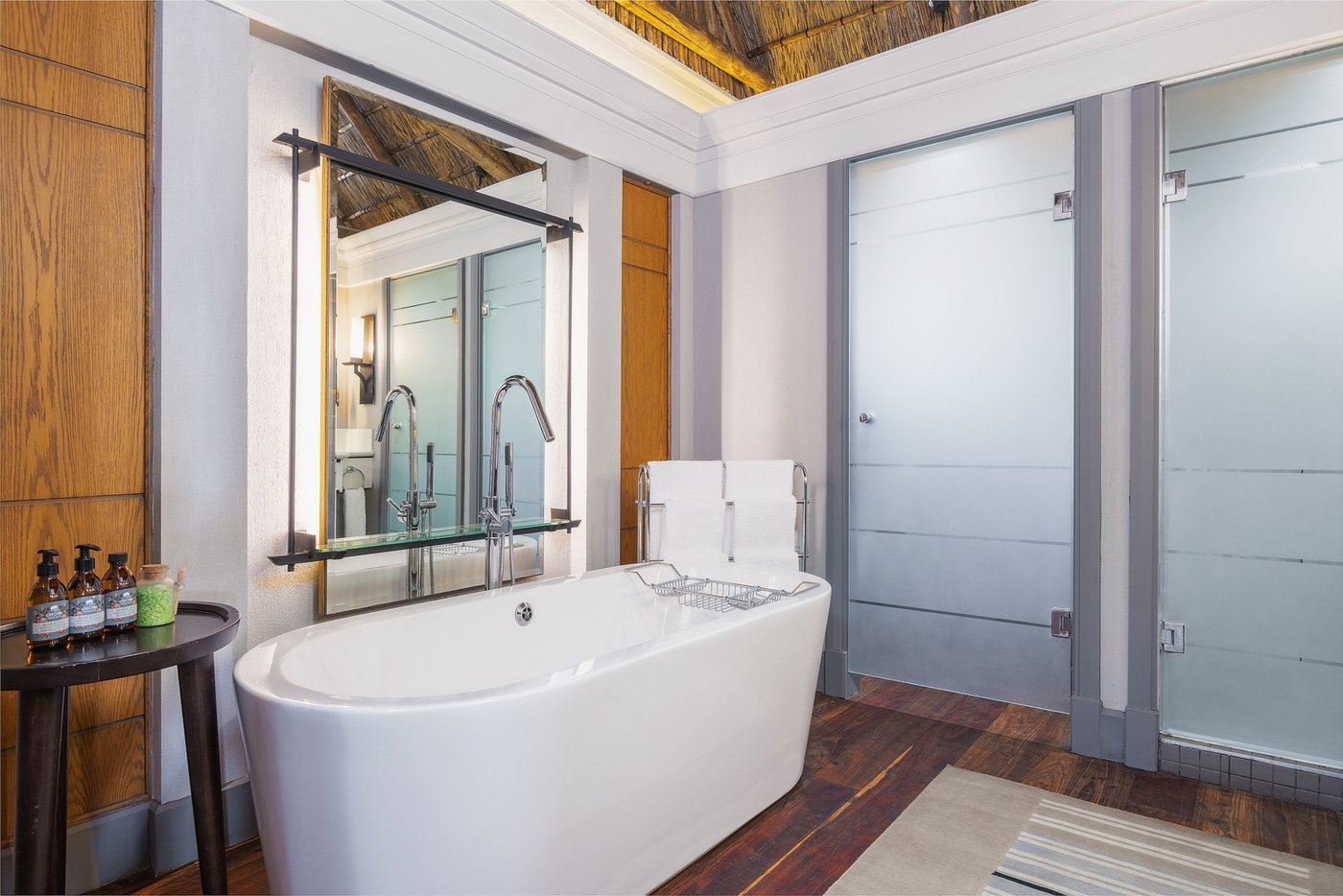 Freestanding bathtub beside glass doors at Chobe Water Villas