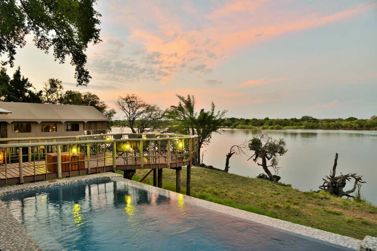 Infinity pool deck overlooking the river at dusk at Jackalberry Chobe, Chobe