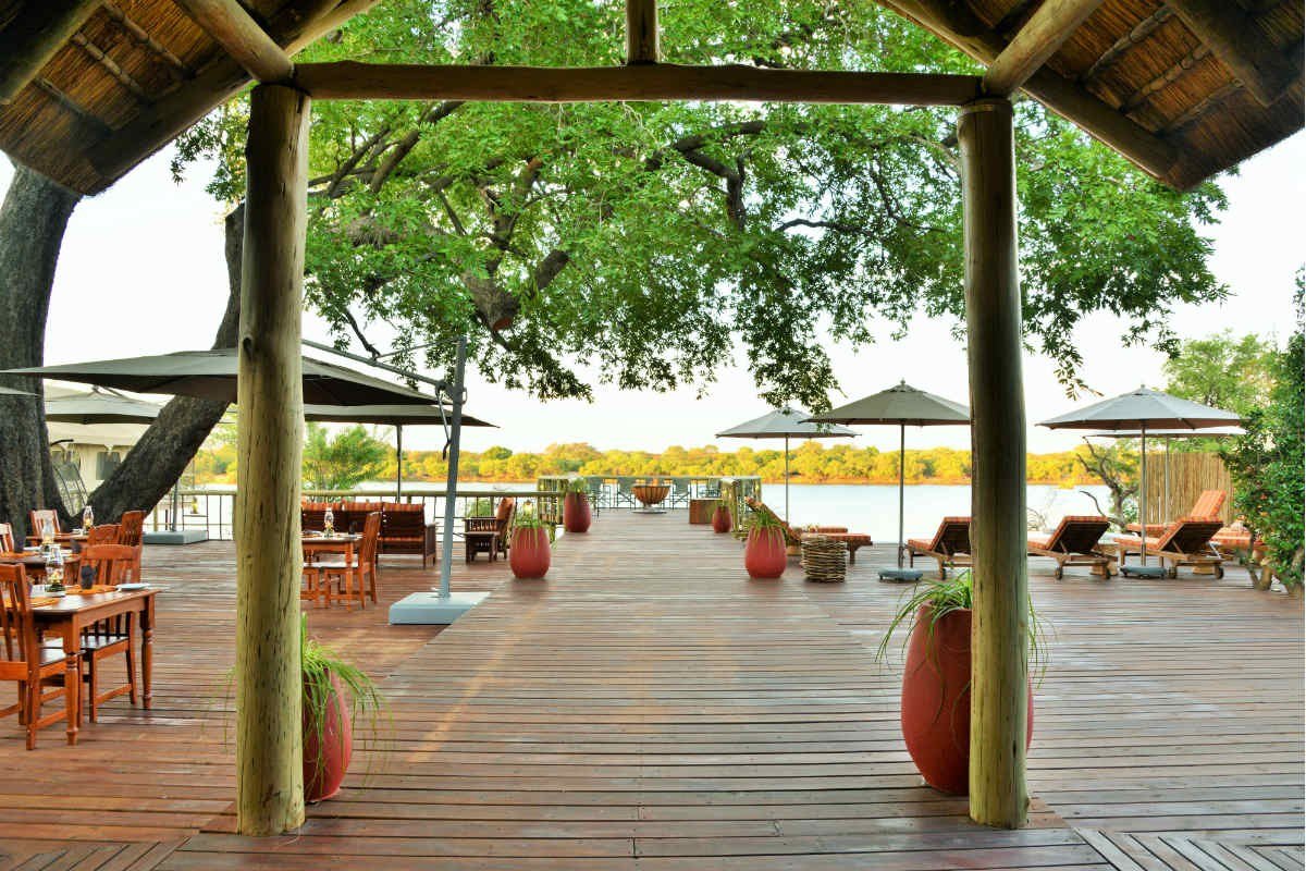 Covered dining pergola with wooden tables at Jackalberry Chobe