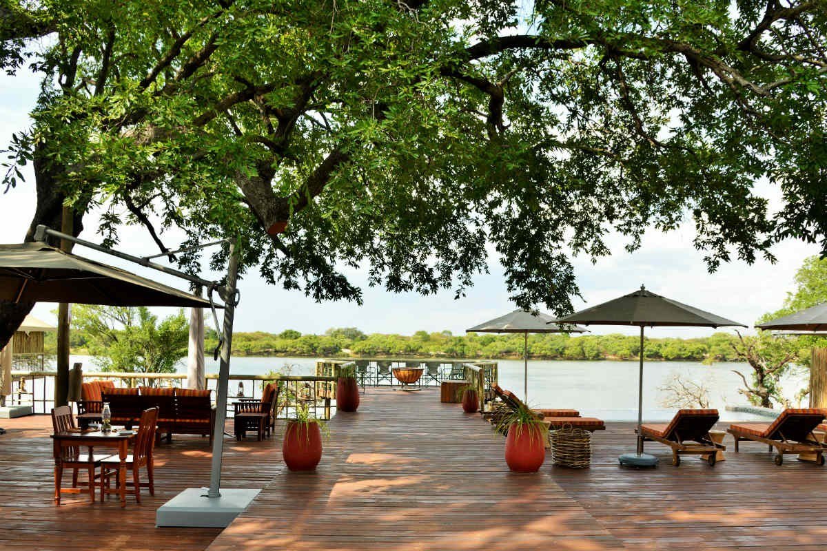 Deck with umbrellas and loungers overlooking the river at Jackalberry Chobe