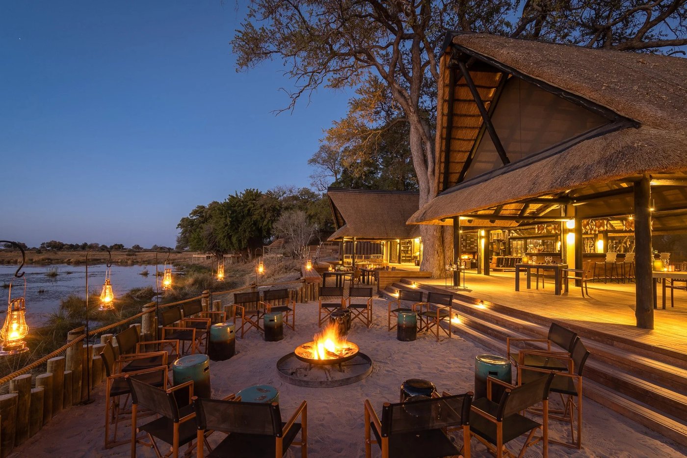 Fire pit dining lounge glowing at dusk at King's Pool Camp
