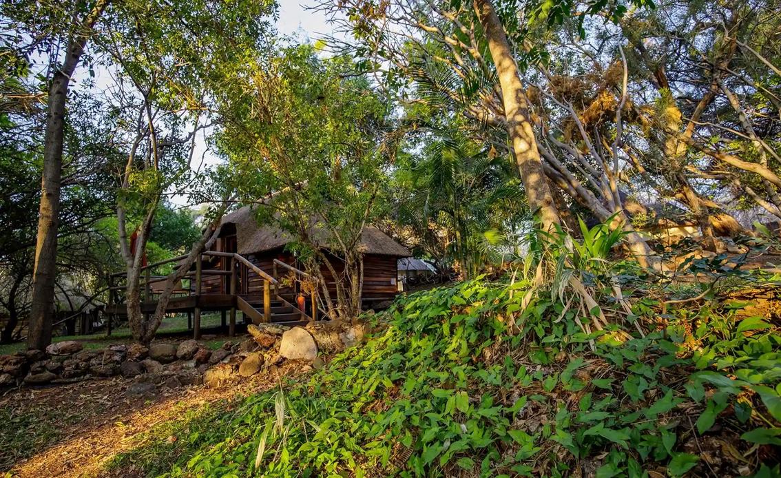 Garden pathway leading to thatched cottages at Kubu Lodge, Chobe