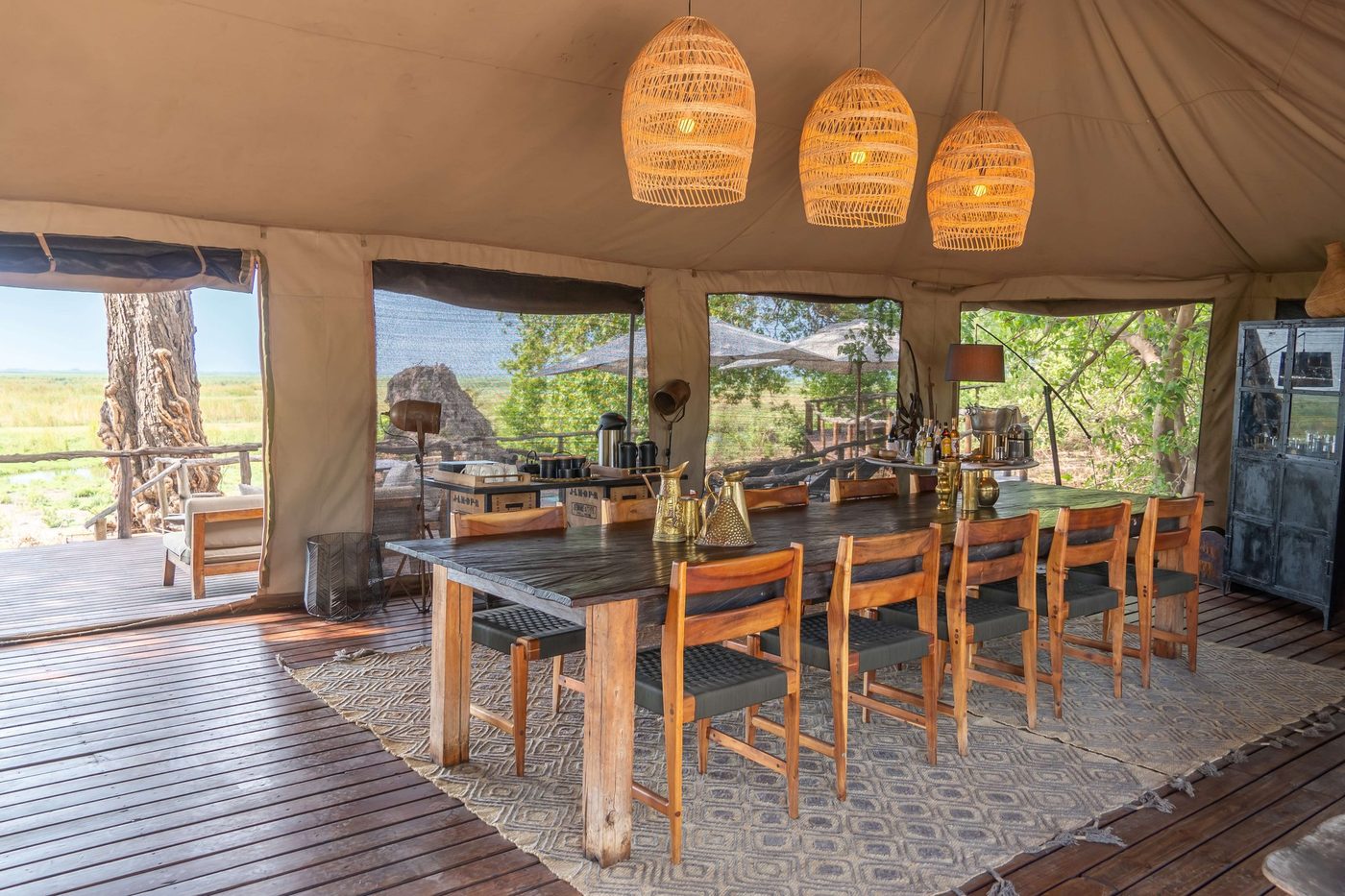 Dining room with pendant lanterns and a long table at Linyanti Ebony
