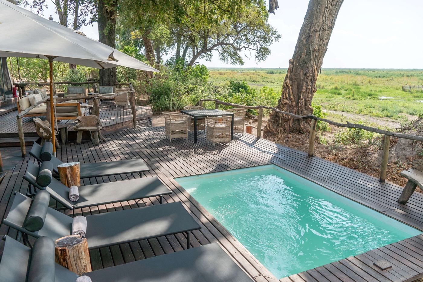 Pool deck with wooden stump tables overlooking the plain at Linyanti Ebony
