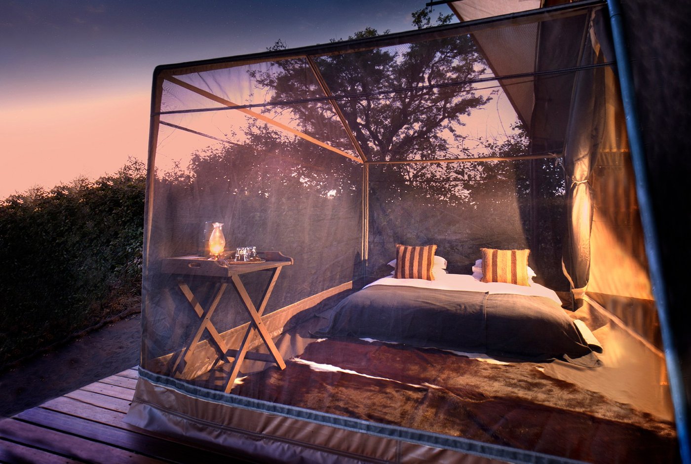 Meru-style tent bedroom with mesh walls open to the bush at Linyanti Expeditions