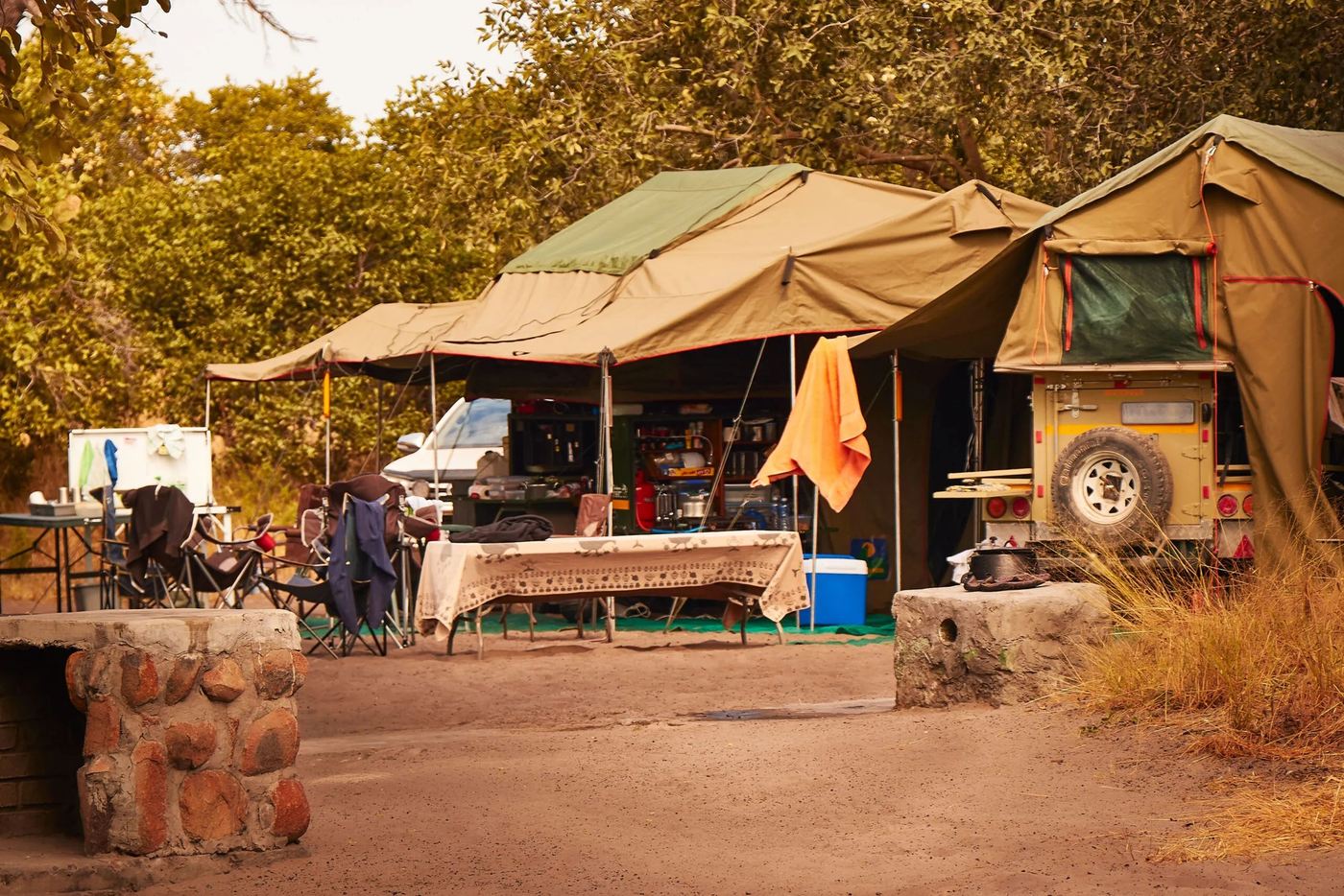 Mobile campsite with tents and a 4x4 set up under trees at Savuti Campsite, Chobe