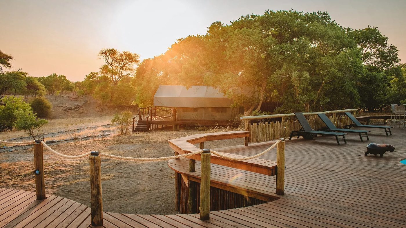 Wooden viewing platform over the water at sunrise at Savuti Campsite