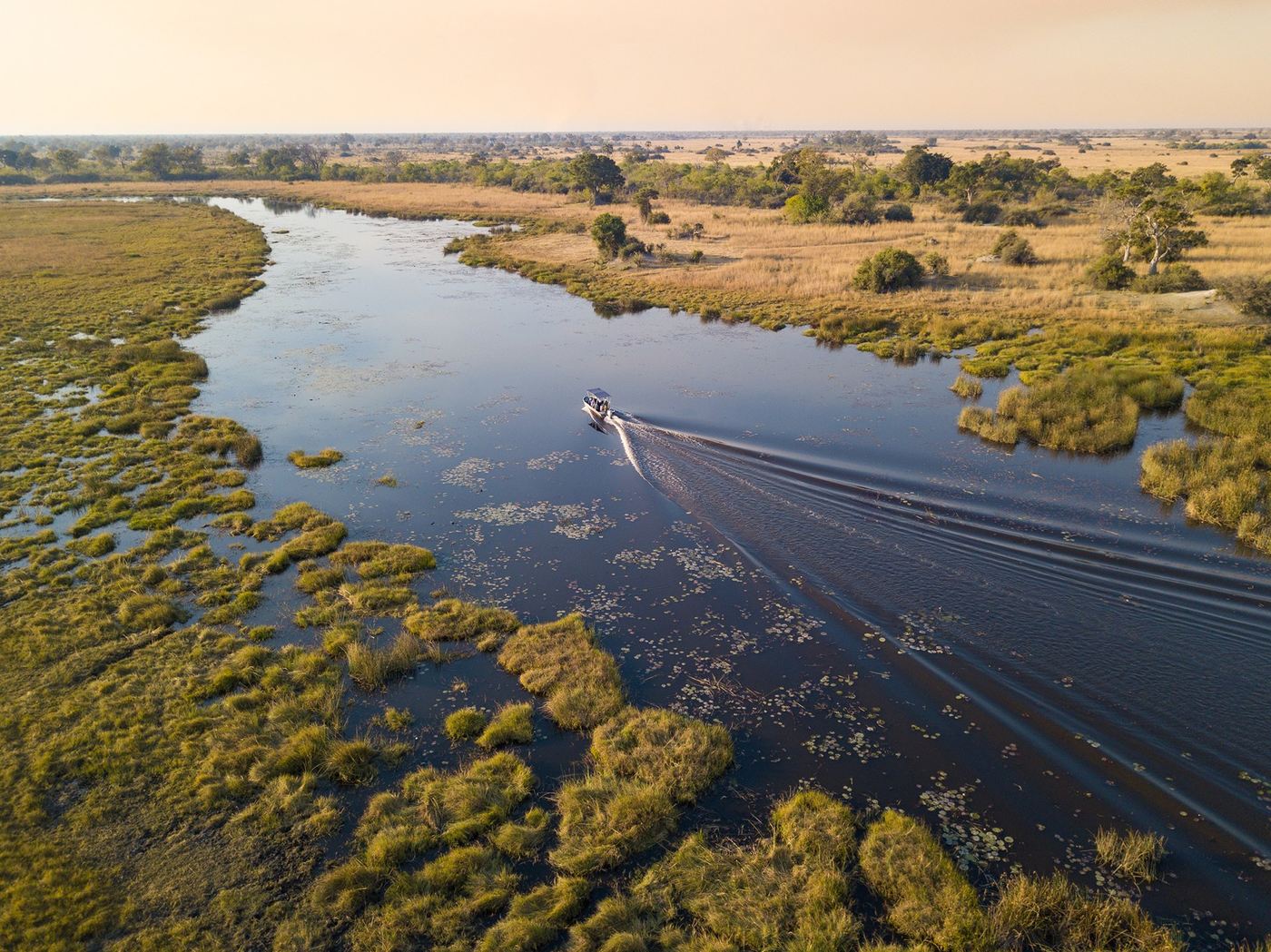 Aerial view of a river bend with a boat near Selinda Camp