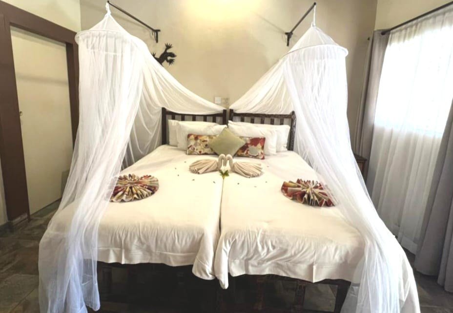 Bedroom with a canopy net over the bed at Thebe River Safaris