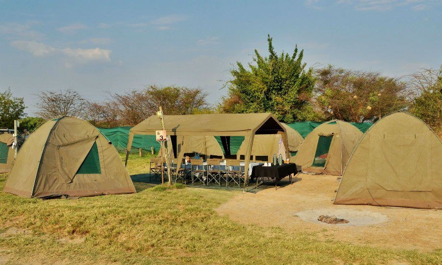 Dome tents pitched beside a dining table at Thebe River Safaris
