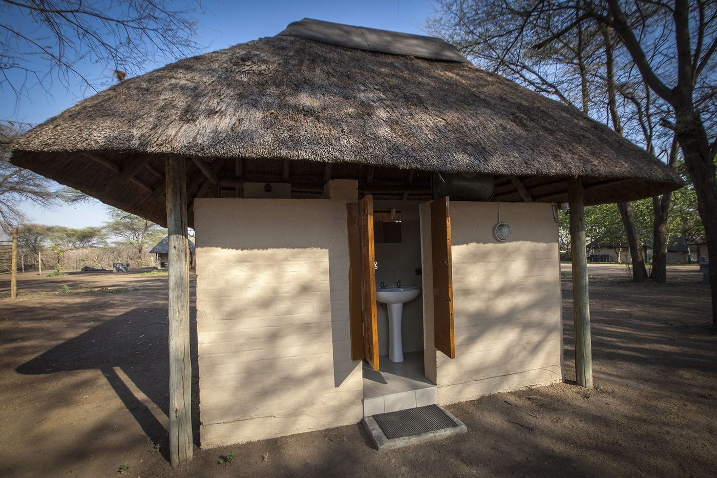 Round thatched guest chalet exterior at Big Five Chobe Lodge
