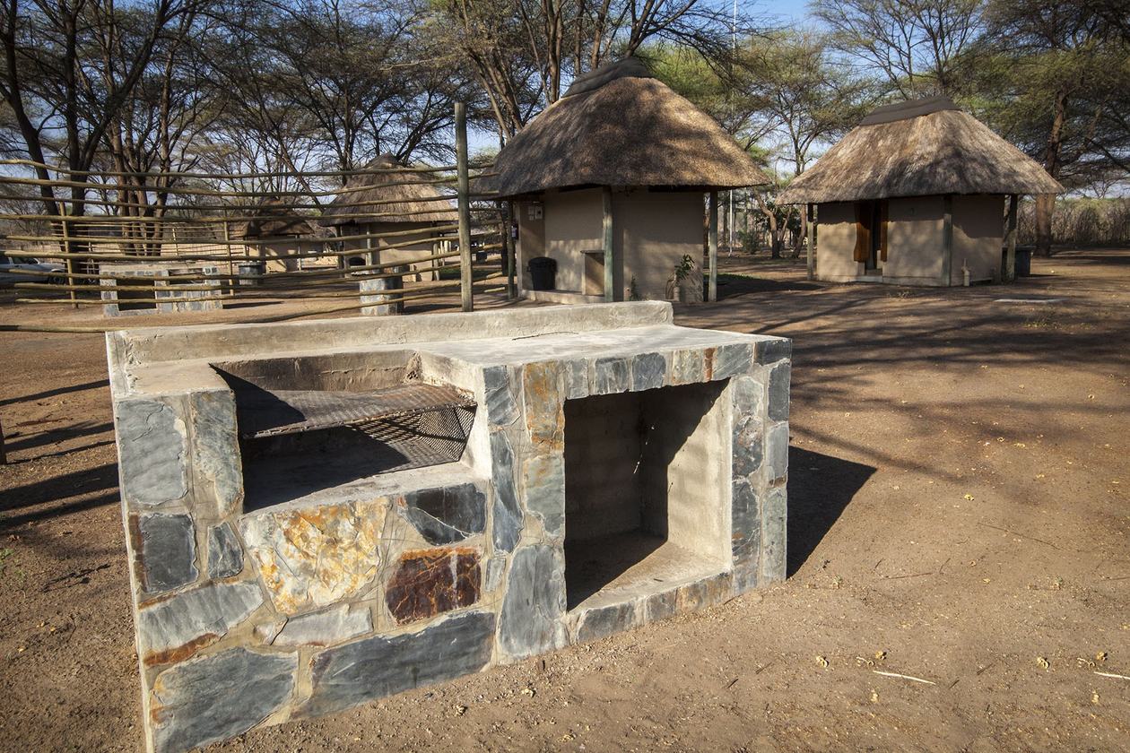 Stone braai fire pit among the rondavels at Big Five Chobe Lodge