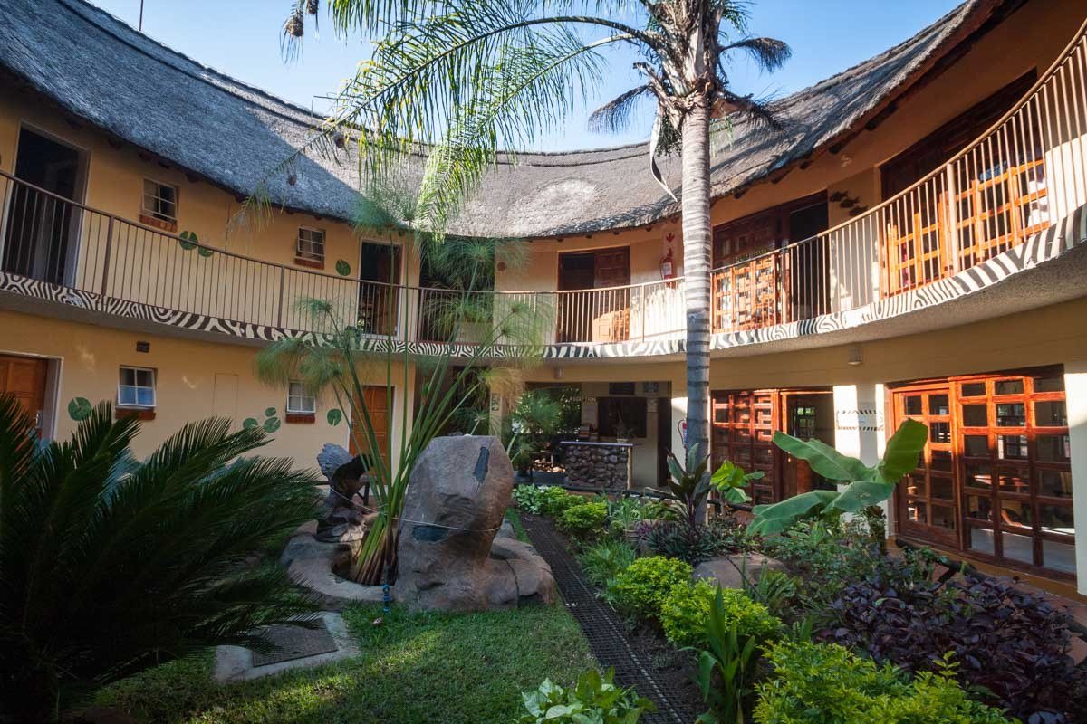Courtyard with a palm tree surrounded by guest room balconies at Water Lily Lodge