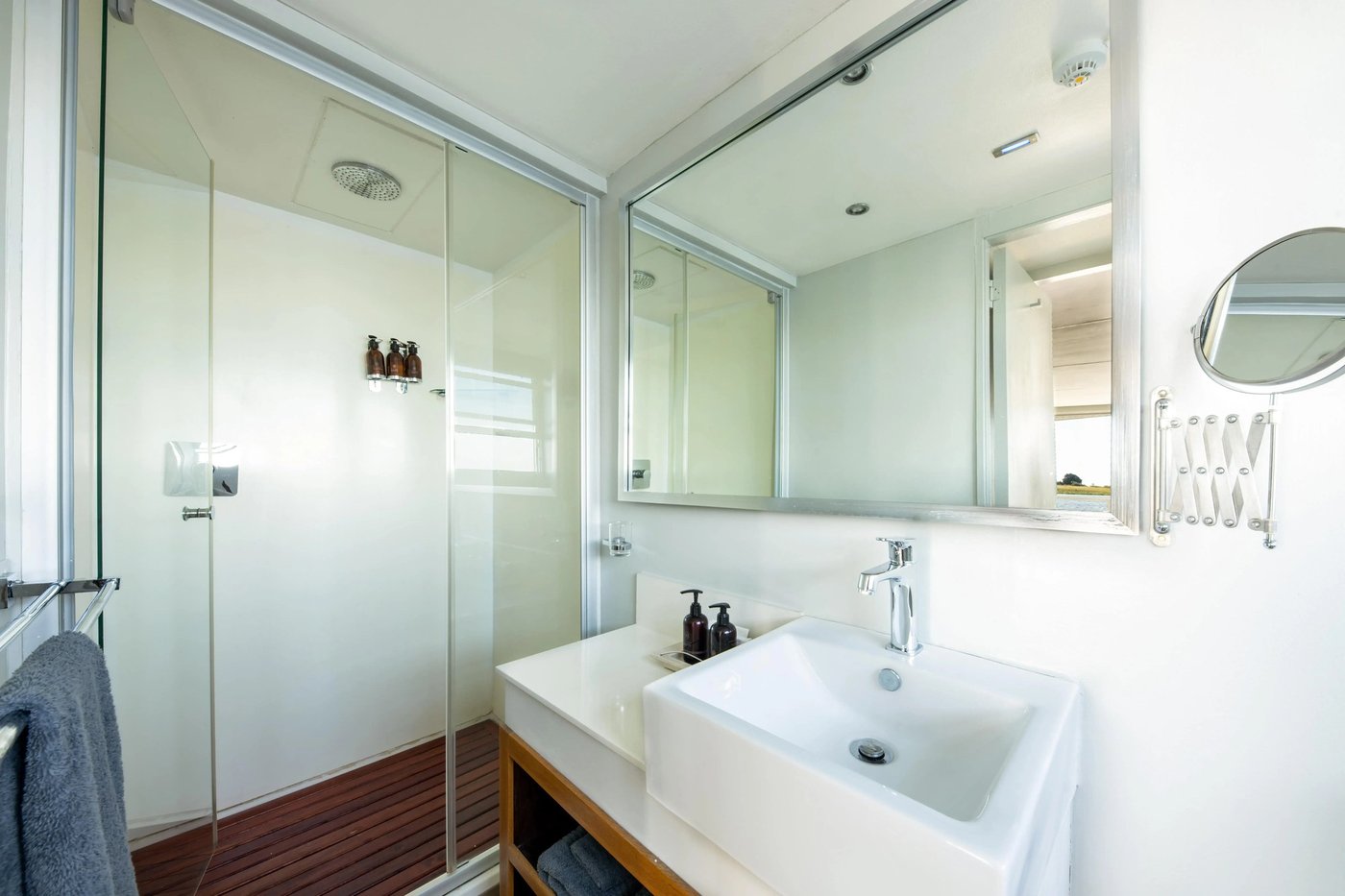 En-suite bathroom with a mirror and river light at Zambezi Queen