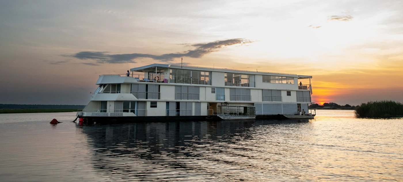 Houseboat silhouetted on the river at golden hour at Zambezi Queen