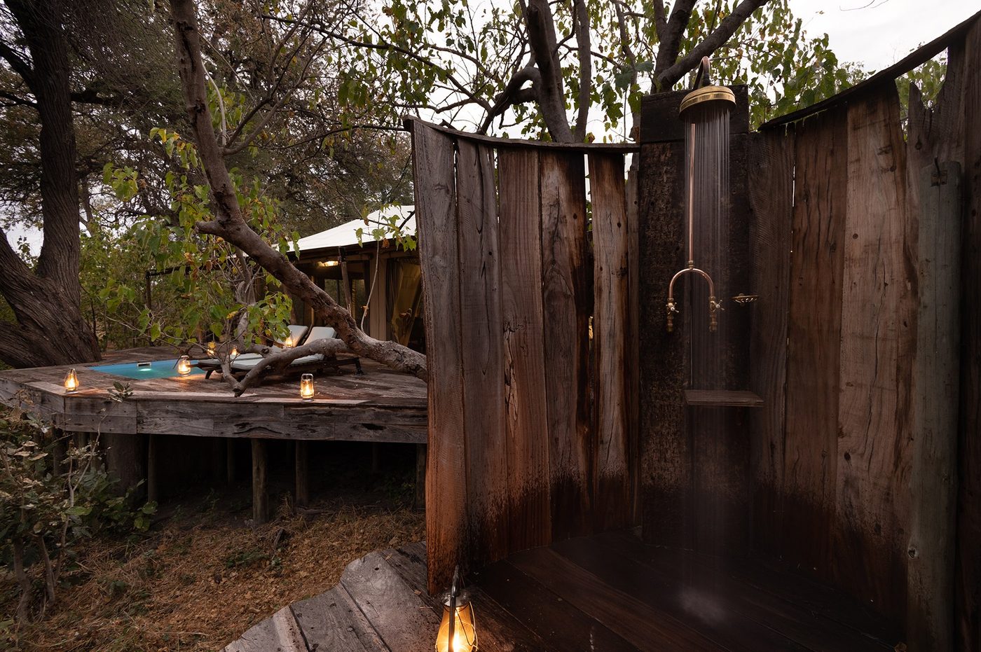 Rustic outdoor shower built from wooden poles at Zarafa Camp