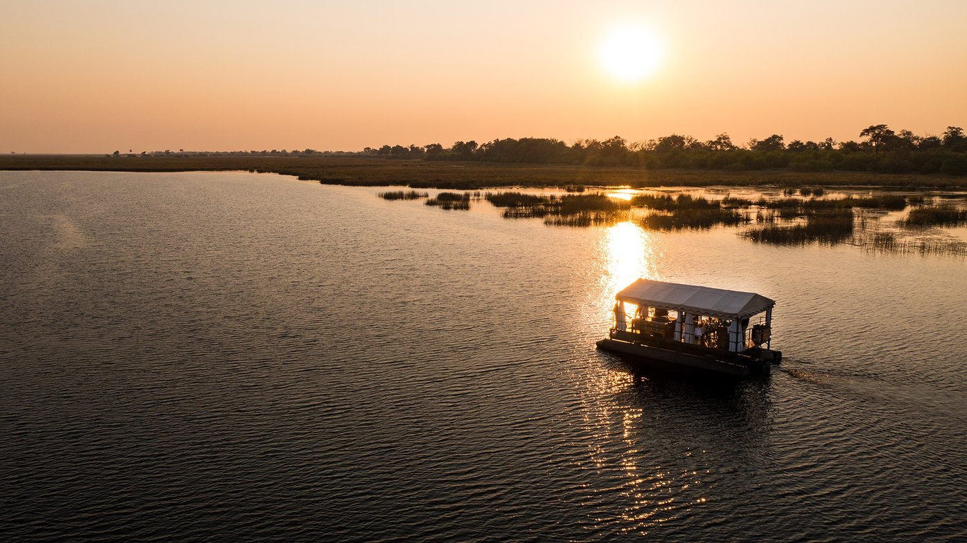 Mokoro silhouetted on the water at sunset near Zarafa Camp